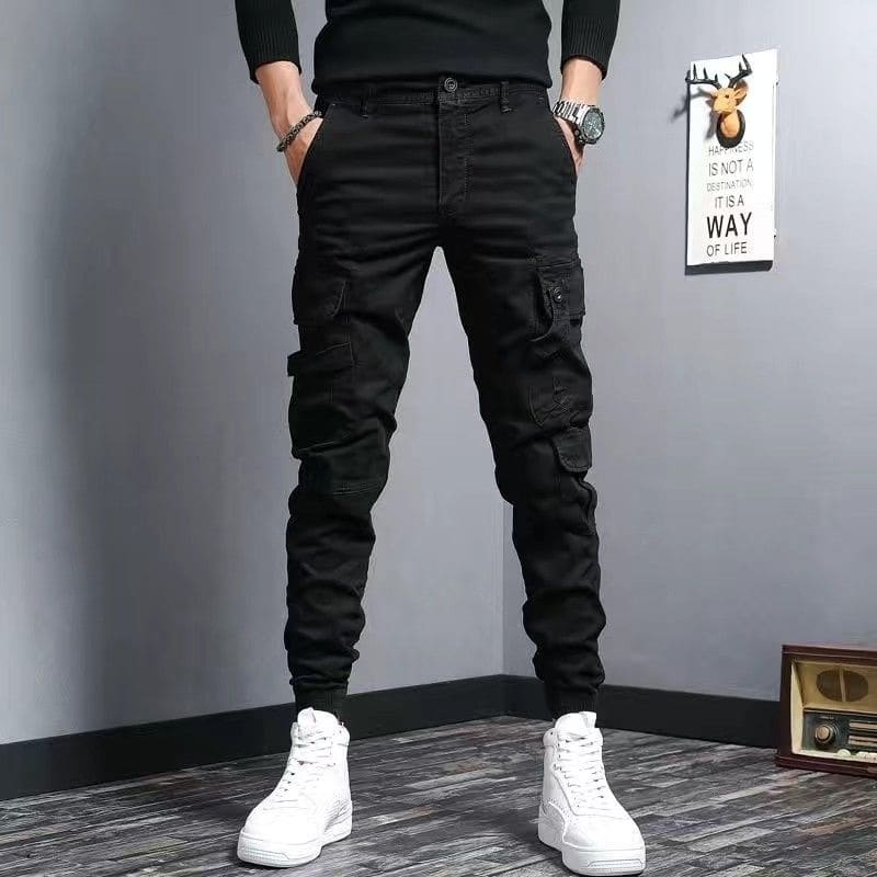 Black cargo pants with multiple pockets worn with white high-top sneakers.