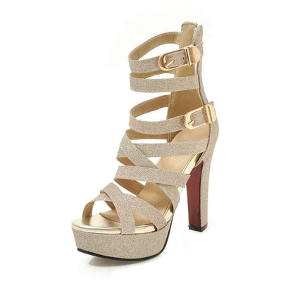 Strappy gold high-heeled platform sandal with glittery straps and buckle closures.