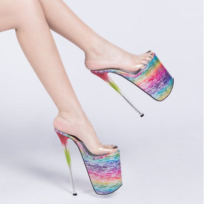 Extremely high platform stiletto shoes with rainbow-colored bases and clear uppers.