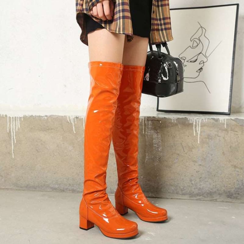 Bright orange patent leather thigh-high boots with chunky heels.