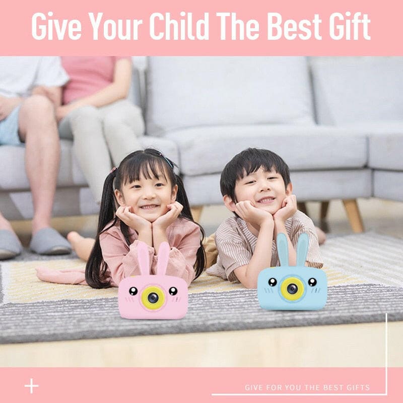 Two smiling children lying on a floor with colorful animal-shaped electronic devices in front of them.