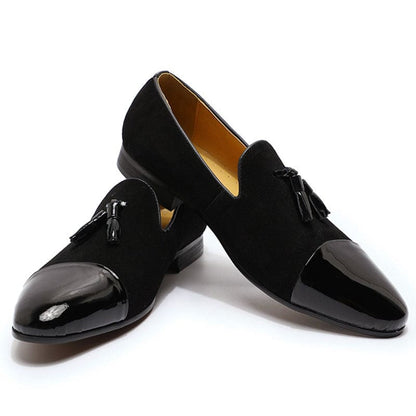 Pair of black dress shoes with patent leather toe caps and tassels.