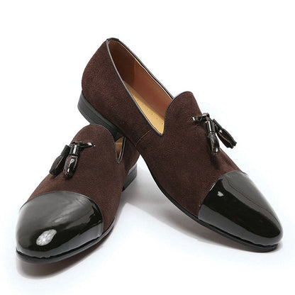 Pair of brown suede loafers with black patent leather toe caps and tassels.