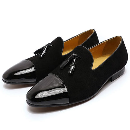 Pair of black patent leather loafers with tassels.