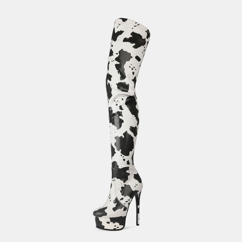 Thigh-high platform boot with a black and white cow print pattern.