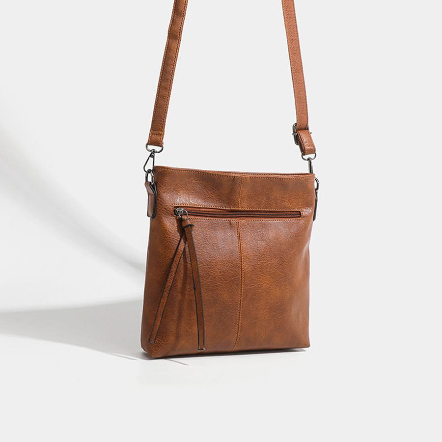 Brown leather crossbody bag with adjustable strap and front zipper in high-end textured artificial style