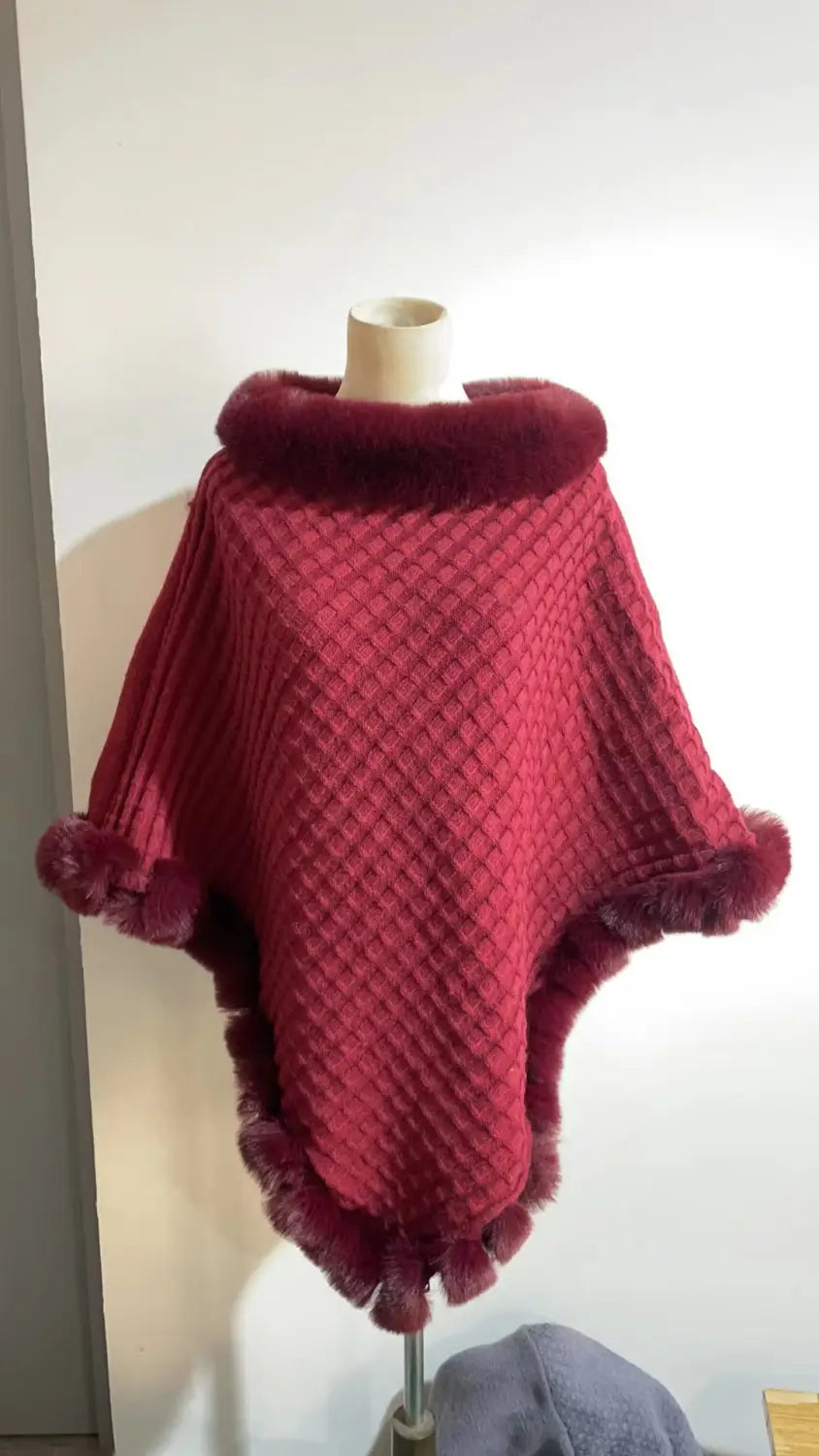 Burgundy knitted poncho with faux fur collar, perfect for cozy luxury style.