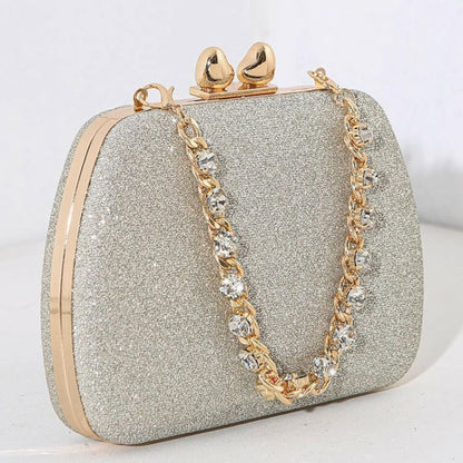 Glittery silver clutch purse with gold clasp and chain strap.