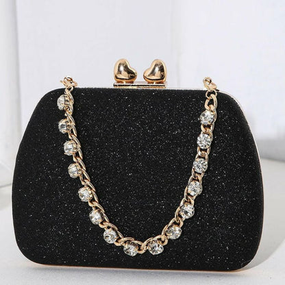 Glittery black clutch purse with a jeweled gold chain strap and clasp.