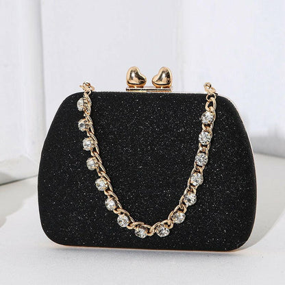 Glittery black evening clutch purse with a jeweled chain strap and gold clasp.