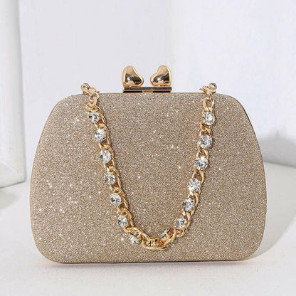 Glittery gold evening clutch purse with a jeweled chain strap and clasp.