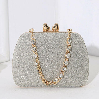 Glittery silver clutch purse with a gold chain strap and clasp.