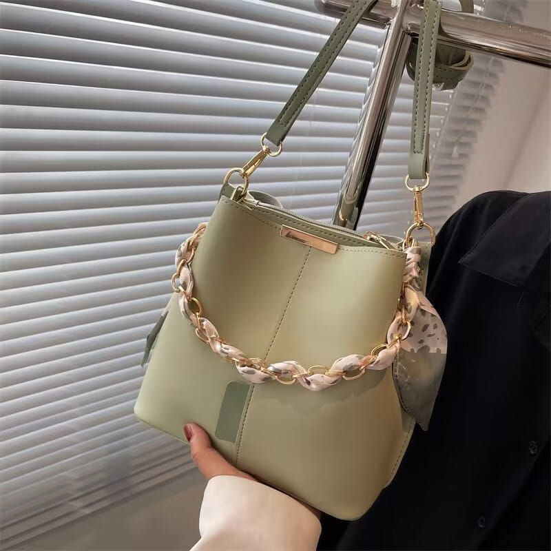 Mint green versatile bucket bag with a trendy shell chain strap for women’s crossbody fashion.