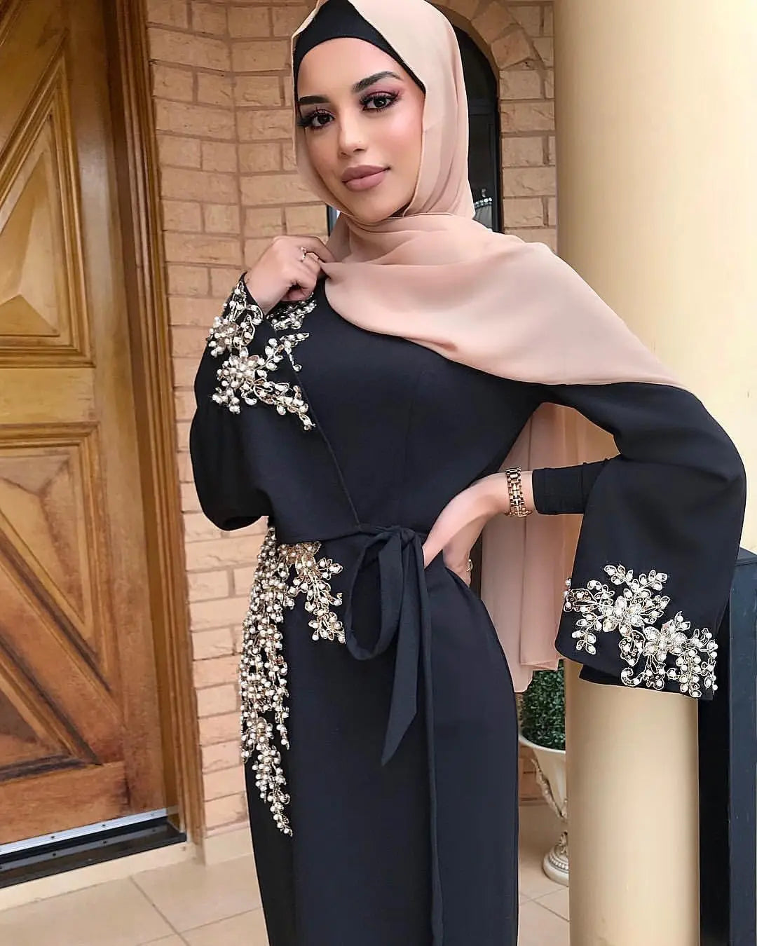 Elegant black ladies muslim embroidered dress with beige hijab and floral sleeves.