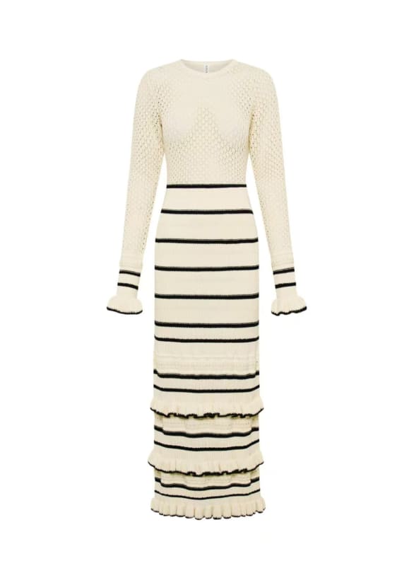 Long-sleeved cream-colored knit dress with horizontal black stripes on the lower half and flared cuffs.