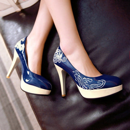 Pair of high-heeled platform shoes with navy blue and white floral design.