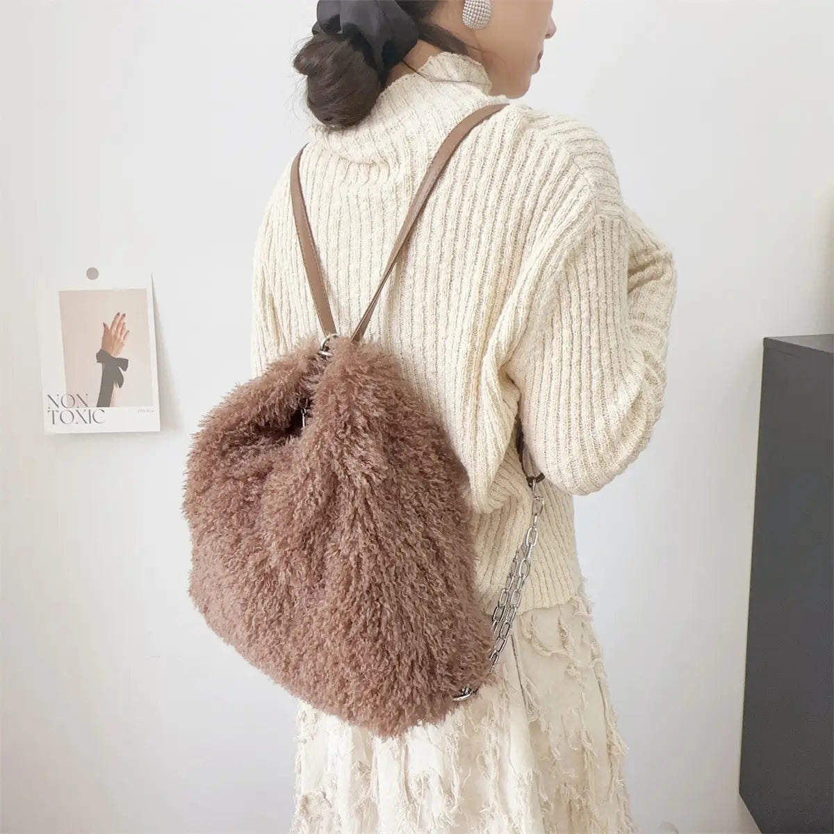 Fluffy mauve faux fur backpack with brown leather straps for plush large capacity style.