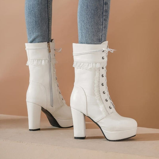 White high-heeled platform boots with lace-up front and side zipper.