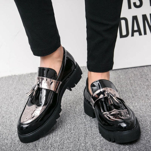 Shiny black patent leather loafers with tassels and chunky soles.