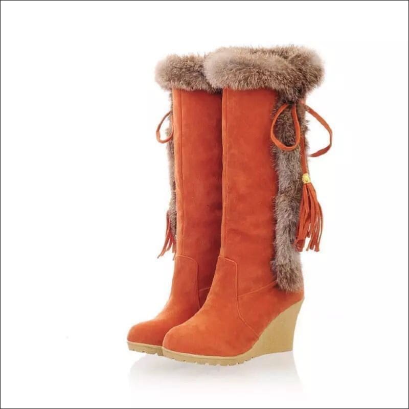 Bottes compensées en faux daim orange avec garniture en fourrure et glands à lacets pour un style hivernal.