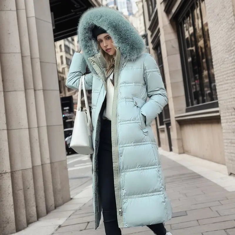 Mint green ladies long padded coat with luxurious fur-trimmed hood for cozy winter style.