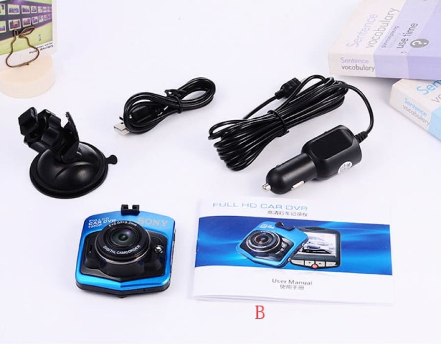 Blue and black compact dashboard camera with accompanying accessories and manual.