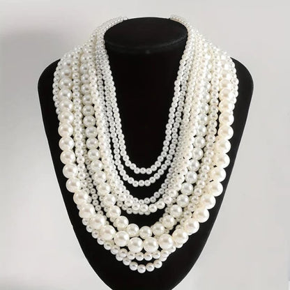 Multi-strand pearl necklace displayed on a black jewelry stand.