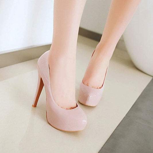 Pair of pale pink high-heeled platform pumps.