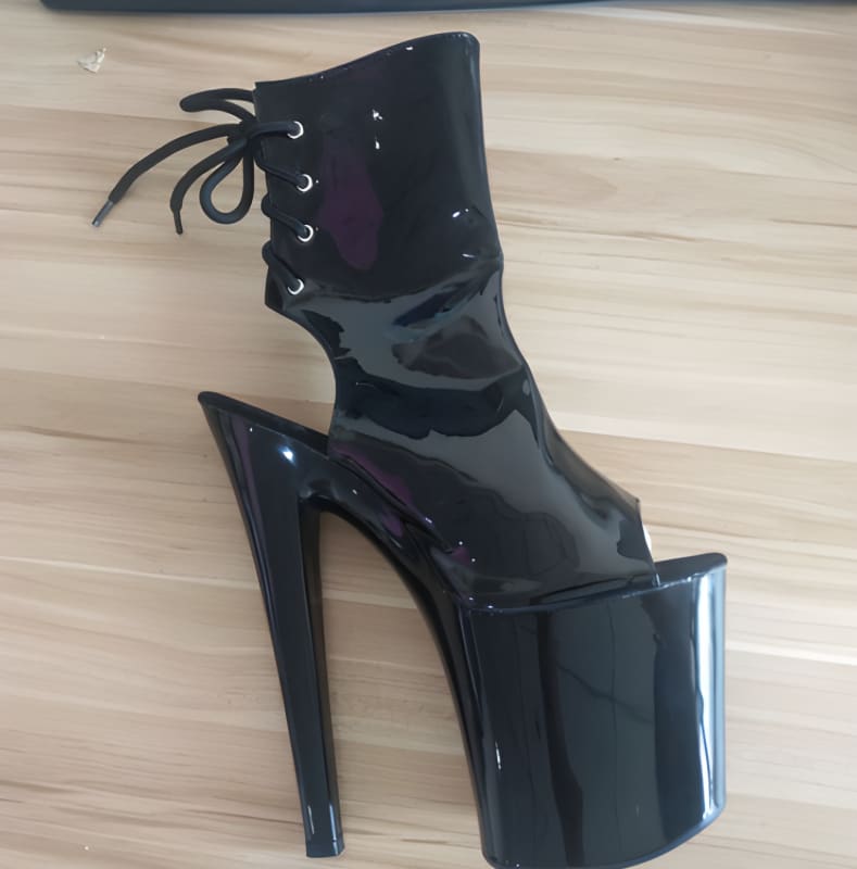 Glossy black platform ankle boot with an extremely high heel and open toe.