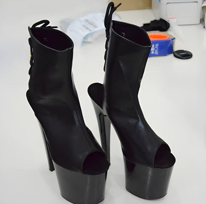 Pair of black high-heeled platform boots with open toes.