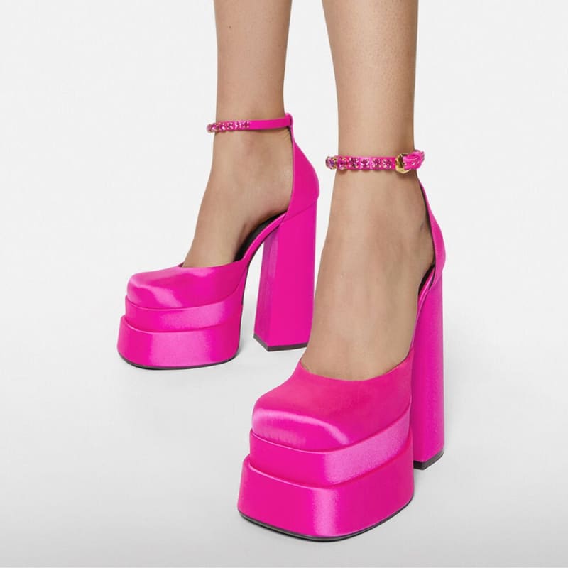 Bright pink platform high heels with chunky soles and ankle straps.