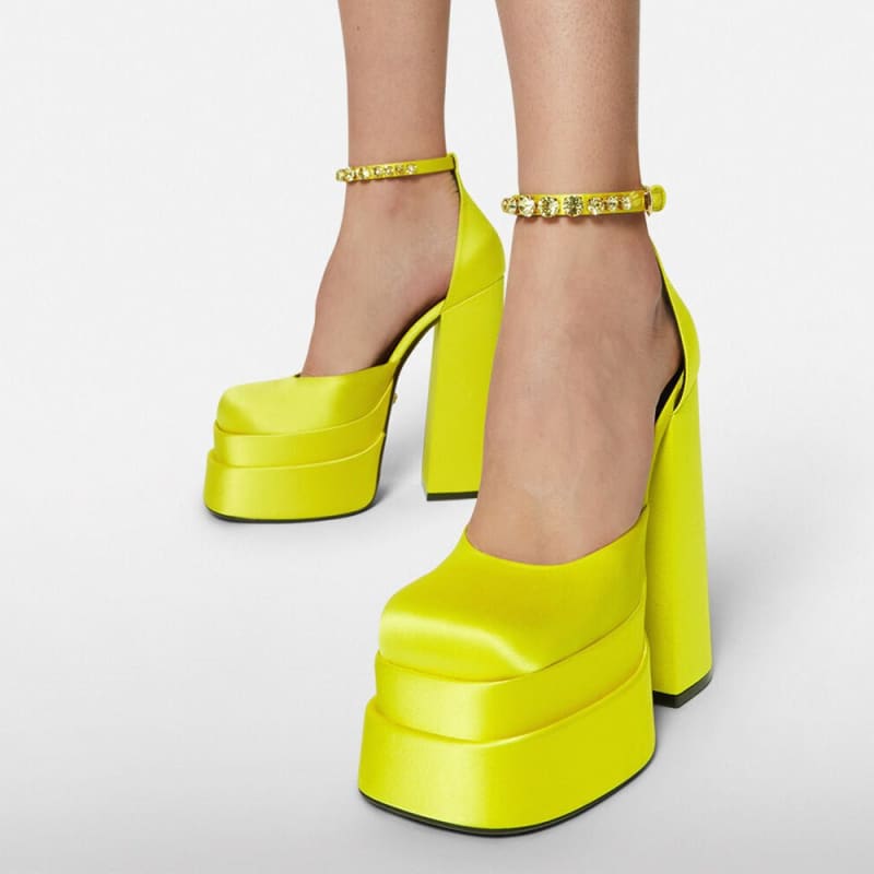 Bright neon yellow platform high heels with chunky soles and ankle straps.