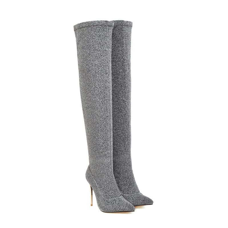 Pair of tall, gray, glittery stiletto boots with pointed toes.