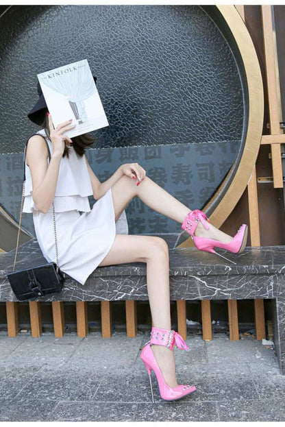 Person sitting on a bench wearing a white outfit and bright pink high heels, holding a book in front of their face.