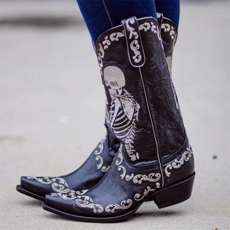 Black cowboy boots with a skeleton design and silver embroidery.