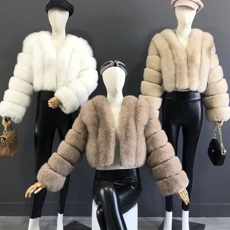 Three fur coats displayed on mannequins with matching hats and accessories.