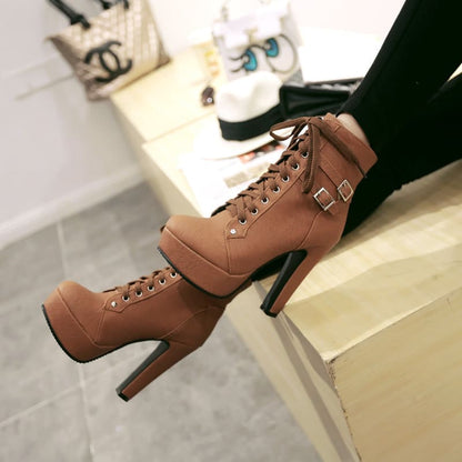 High-heeled brown leather ankle boots with laces and a buckle strap.