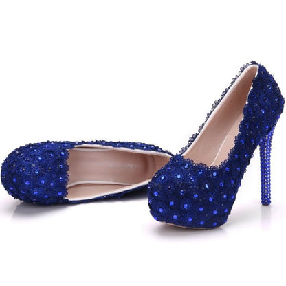 Pair of royal blue high-heeled shoes adorned with sparkling crystals or sequins.