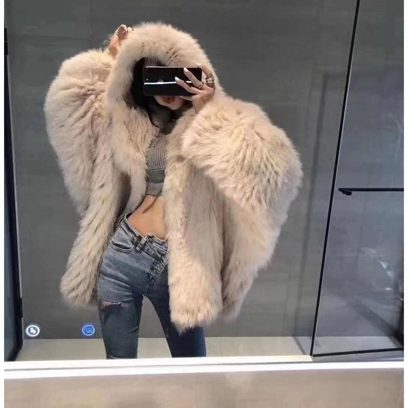 Fluffy cream-colored fur coat worn over jeans and a cropped top.