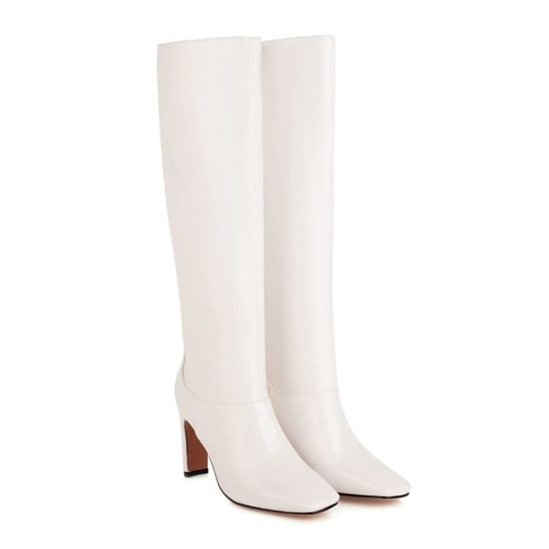 Pair of white knee-high leather boots with block heels.