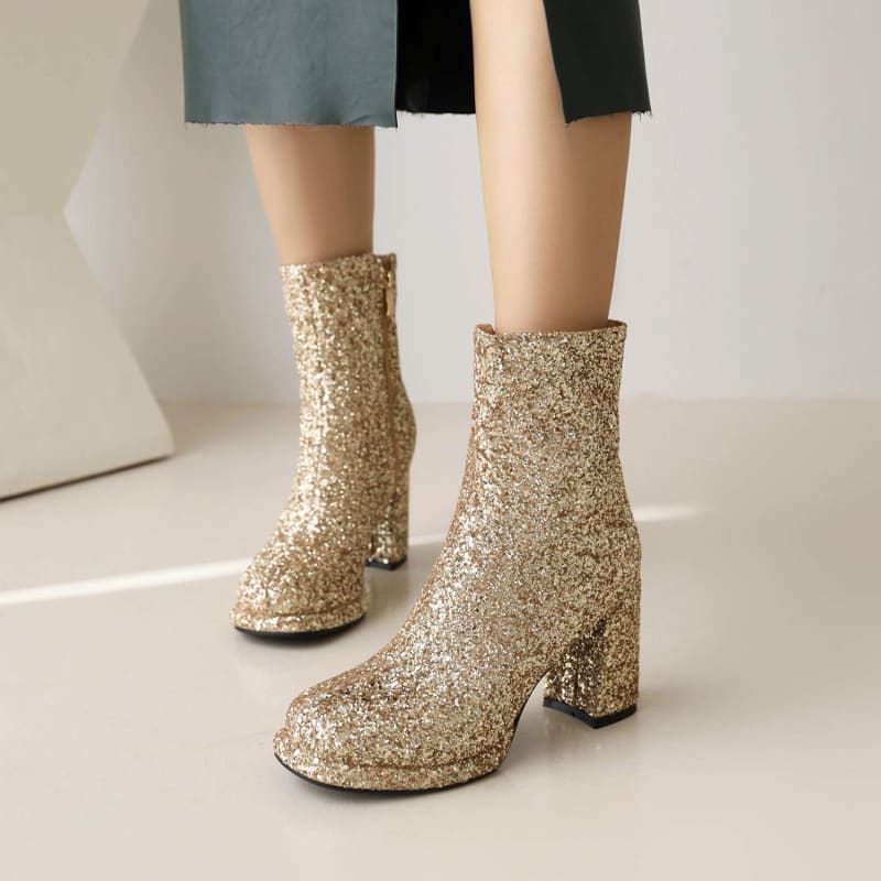 Pair of glittery gold ankle boots with chunky heels.