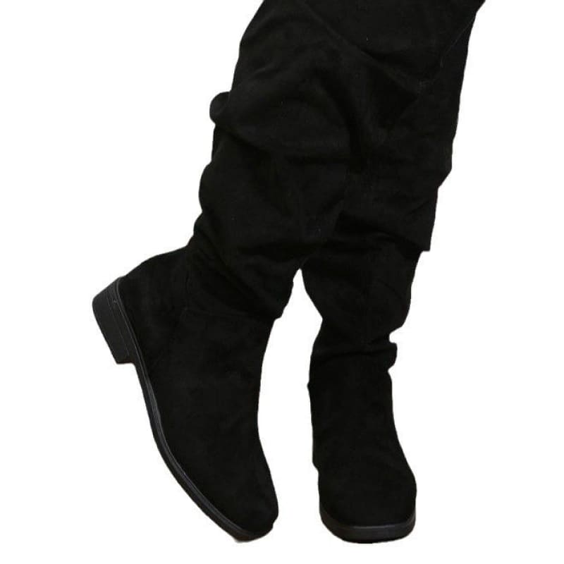 Black knee-high suede boot with a low heel.