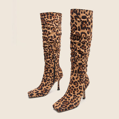 Pair of knee-high leopard print boots with stiletto heels.