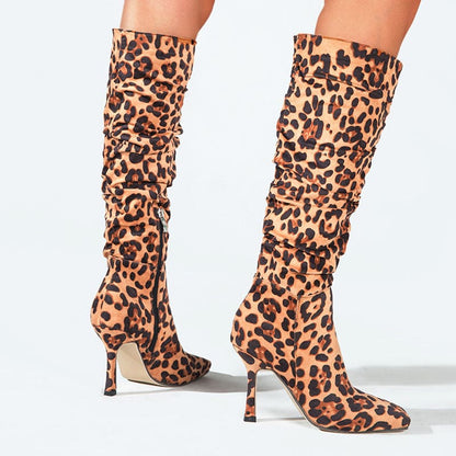 Knee-high leopard print boots with stiletto heels.