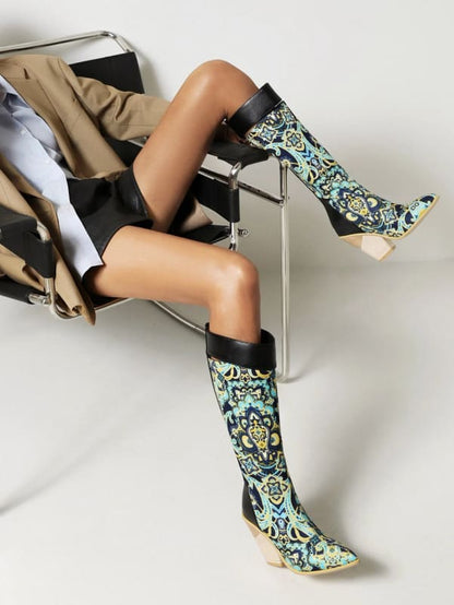 Pair of ornate, floral-patterned knee-high boots with pointed toes and high heels.