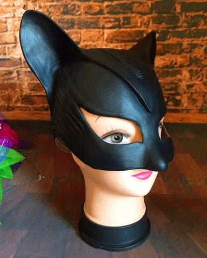 Black cat-shaped mask with pointed ears covering the upper half of a mannequin head.