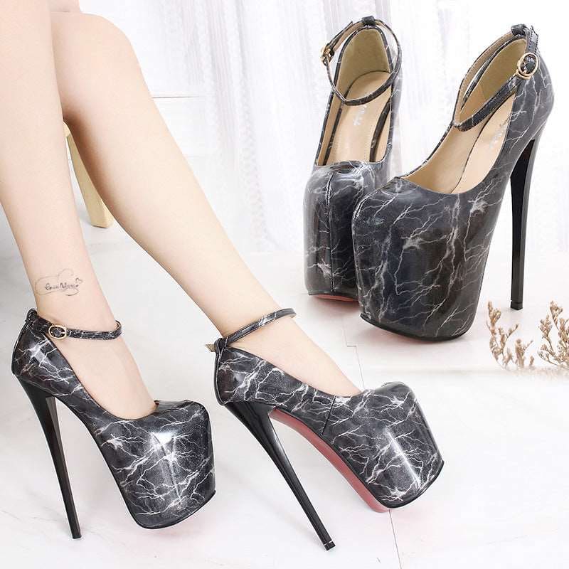 Extremely high platform stiletto heels with a marbled black and white pattern.