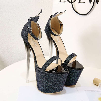 Pair of glittery black platform high heels with extremely tall, clear stiletto heels.