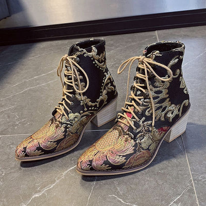 Pair of ornate, embroidered ankle boots with pointed toes and lace-up fronts.