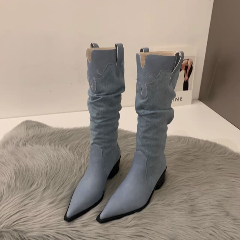 Pair of light blue slouchy cowboy boots with pointed toes.